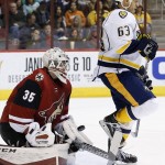 Arizona Coyotes' Louis Domingue (35) makes a save behind Nashville Predators' Mike Ribeiro (63) during the first period of an NHL hockey game Saturday, Jan. 9, 2016, in Glendale, Ariz. (AP Photo/Ross D. Franklin)