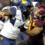 West Virginia running back Wendell Smallwood (4) runs the football as Arizona State defensive back Chad Adams (21) tries to bring him down during the first half of the Cactus Bowl NCAA college football game, Saturday, Jan. 2, 2016, in Phoenix. (AP Photo/Ross D. Franklin)