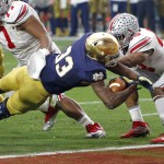 Notre Dame running back Josh Adams (33) scores a touchdown as Ohio State linebacker Darron Lee, right, defends during the first half of the Fiesta Bowl NCAA College football game, Friday, Jan. 1, 2016, in Glendale, Ariz.  (AP Photo/Rick Scuteri)