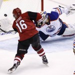 Arizona Coyotes' Max Domi (16) scores a goal on Edmonton Oilers' Anders Nilsson, top right, of Sweden, as Oilers' Mark Letestu (55) watches during the second period of an NHL hockey game Tuesday, Jan. 12, 2016, in Glendale, Ariz. (AP Photo/Ross D. Franklin)