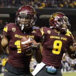 Arizona State 's Tim White, left, celebrates with teammate Lloyd Carrington (8) after his score of two points after returning a blocked extra-point kick against West Virginia during the first half of the Cactus Bowl NCAA college football game Saturday, Jan. 2, 2016, in Phoenix. (AP Photo/Ross D. Franklin)