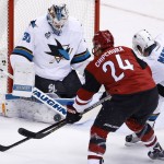 San Jose Sharks' Martin Jones, left, makes a save on a shot by Arizona Coyotes' Kyle Chipchura (24) as Sharks' Paul Martin (7) defends during the second period of an NHL hockey game, Thursday, Jan. 21, 2016, in Glendale, Ariz. (AP Photo/Ross D. Franklin)