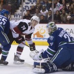 Vancouver Canucks goalie Jacob Markstrom (25) stops a shot from Arizona Coyotes center Laurent Dauphin (76) as Vancouver Canucks defenseman Alex Biega (55) looks on during first period NHL hockey action in Vancouver, British Columbia, Canada, Monday, Jan. 4, 2016. (Jonathan Hayward/The Canadian Press via AP)