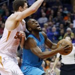 Charlotte Hornets' Kemba Walker, right, shouts as he collides with Phoenix Suns' Jon Leuer, left, during the first half of an NBA basketball game Wednesday, Jan. 6, 2016, in Phoenix. (AP Photo/Ross D. Franklin)
