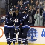 Winnipeg Jets' Tyler Myers (57), Dustin Byfuglien (33) and Andrew Ladd (16) celebrate after Byfuglien scored his second goal against the Arizona Coyotes, during the second period of an NHL hockey game Tuesday, Jan 26, 2016, in Winnipeg, Manitoba. (Trevor Hagan/The Canadian Press via AP)