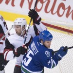 Arizona Coyotes defenseman Klas Dahlbeck (34) tries to clear Vancouver Canucks right wing Derek Dorsett (15) from in front of Arizona Coyotes goalie Louis Domingue (35) during second period NHL action Vancouver, British Columbia, Monday, Jan. 4, 2016. (Jonathan Hayward/The Canadian Press via AP)