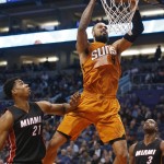 Phoenix Suns center Tyson Chandler (4) dunks in front of Miami Heat center Hassan Whiteside (21) and guard Dwyane Wade during the third quarter of an NBA basketball game, Friday, Jan. 8, 2016, in Phoenix. The Heat won 103-95. (AP Photo/Rick Scuteri)