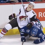 Vancouver Canucks center Bo Horvat (53) fights for control of the puck with Arizona Coyotes defenseman Connor Murphy (5) during second period NHL action Vancouver, British Columbia, Monday, Jan. 4, 2016. (Jonathan Hayward/The Canadian Press via AP)