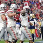 Ohio State running back Ezekiel Elliott, right, salutes as he celebrates with Billy Price, center, after scoring a touchdown against Notre Dame  during the first half of the Fiesta Bowl NCAA College football game, Friday, Jan. 1, 2016, in Glendale, Ariz.  (AP Photo/Ross D. Franklin)