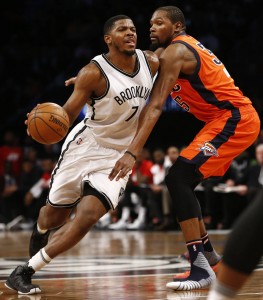Brooklyn Nets forward Joe Johnson (7) drives to the basket as a shoeless Oklahoma City Thunder forward Kevin Durant (35) defends him in the second half of an NBA basketball game, Sunday, Jan. 24, 2016, in New York after Durant lost his shoe on the play. The Nets defeated the Thunder 116-106. (AP Photo/Kathy Willens)