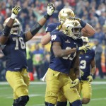 Notre Dame running back Josh Adams (33) celebrates with teammates after scoring a touchdown against Ohio State during the first half of the Fiesta Bowl NCAA College football game, Friday, Jan. 1, 2016, in Glendale, Ariz.  (AP Photo/Rick Scuteri)
