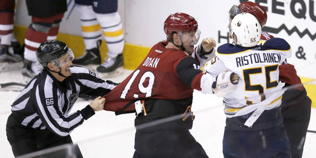 Arizona Coyotes right wing Shane Doan (19) is held back from going after Buffalo Sabres defenseman ...