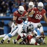 Arizona Cardinals' Carson Palmer fumbles as he is hit by Carolina Panthers' Kawann Short and Mario Addison (97) during the first half the NFL football NFC Championship game Sunday, Jan. 24, 2016, in Charlotte, N.C. (AP Photo/Bob Leverone)