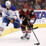 Arizona Coyotes' Max Domi (16) tries to keep the puck away from Edmonton Oilers' Lauri Korpikoski (28), of Finland, during the first period of an NHL hockey game Tuesday, Jan. 12, 2016, in Glendale, Ariz. (AP Photo/Ross D. Franklin)