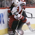 New Jersey Devils' Damon Severson (28) checks Arizona Coyotes' Anthony Duclair into the boards during the first period of an NHL hockey game, Saturday, Jan. 16, 2016, in Glendale, Ariz. (AP Photo/Ralph Freso)