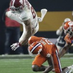 Alabama's O.J. Howard (88) is stopped by Clemson's Adrian Baker after a catch during the second half of the NCAA college football playoff championship game Monday, Jan. 11, 2016, in Glendale, Ariz. (AP Photo/Chris Carlson)