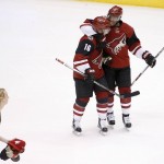 Arizona Coyotes' Max Domi (16) gets a hug from teammate Anthony Duclair, right, after Domi recorded a hat trick against the Edmonton Oilers, as a member of the Coyotes Paw Patrol picks up hats thrown on the ice, during the third period of an NHL hockey game Tuesday, Jan. 12, 2016, in Glendale, Ariz.  The Coyotes defeated the Oilers 4-3. (AP Photo/Ross D. Franklin)