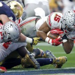 Ohio State running back Ezekiel Elliott (15) dives over the goal line for a touchdown against Notre Dame during the first half of the Fiesta Bowl NCAA College football game, Friday, Jan. 1, 2016, in Glendale, Ariz.  (AP Photo/Ross D. Franklin)