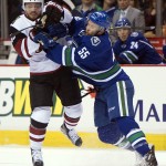 Vancouver Canucks defenseman Alex Biega (55) fights for control of the puck with Arizona Coyotes center Max Domi (16) during first period NHL action Vancouver,  British Columbia, Monday, Jan. 4, 2016. (Jonathan Hayward/The Canadian Press via AP)