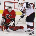 Calgary Flames goalie Karri Ramo, left, from Finland, makes a save despite being screened by Arizona Coyotes' Shane Doan during the first period of an NHL hockey game Thursday, Jan. 7, 2015, in Calgary, Alberta. (Larry MacDougal/The Canadian Press via AP)