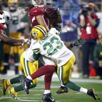 Arizona Cardinals wide receiver Larry Fitzgerald (11) is hit after the catch by Green Bay Packers cornerback Damarious Randall (23) during the second half of an NFL divisional playoff football game, Saturday, Jan. 16, 2016, in Glendale, Ariz. (AP Photo/Rick Scuteri)