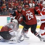 Arizona Coyotes' Louis Domingue (35) makes a save on a shot by Detroit Red Wings' Justin Abdelkader (8) as Coyotes' Michael Stone (26) and Nicklas Grossmann (2), of Sweden, defend during the second period of an NHL hockey game Thursday, Jan. 14, 2016, in Glendale, Ariz. (AP Photo/Ross D. Franklin)