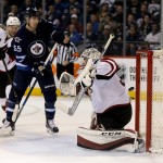 Arizona Coyotes' Martin Hanzal (11) tries to check Winnipeg Jets' Mark Scheifele (55) as a shot by Nikolaj Ehlers, not shown, beats goalie Louis Domingue (35) for Ehlers' third goal of the night, during the second period of an NHL hockey game Tuesday, Jan 26, 2016, in Winnipeg, Manitoba. (Trevor Hagan/The Canadian Press via AP)
