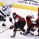 Los Angeles Kings' Dustin Brown (23) scores a goal against Arizona Coyotes' Louis Domingue (35) as Coyotes' Michael Stone (26) and Kevin Connauton (44) try to defend during the second period of an NHL hockey game Saturday, Jan. 23, 2016, in Glendale, Ariz. (AP Photo/Ross D. Franklin)