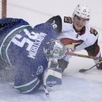 Arizona Coyotes center Laurent Dauphin (76) crashes into Vancouver Canucks goalie Jacob Markstrom (25) during second period NHL action Vancouver, British Columbia, Monday, Jan. 4, 2016. (Jonathan Hayward/The Canadian Press via AP)