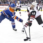 Arizona Coyotes' Jordan Martinook (48) and Edmonton Oilers' Andrej Sekera (2) battle for the puck during first period NHL action in Edmonton, on Saturday, Jan. 2, 2016. (Jason Franson/The Canadian Press via AP)