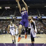 Phoenix Suns guard Devin Booker, center, drives for the layup as Sacramento Kings' Omri Casspi, of Israel, left, and Marco Belinelli, of Italy, look on during the second half of an NBA basketball game in Saturday, Jan. 2, 2016, in Sacramento, Calif.  The Kings won 142-119.(AP Photo/Rich Pedroncelli)