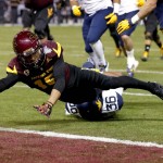 Arizona State wide receiver Devin Lucien (15) scores a touchdown as West Virginia linebacker Shaq Petteway (36) defends during the first half of the Cactus Bowl NCAA college football game, Saturday, Jan. 2, 2016, in Phoenix. (AP Photo/Ross D. Franklin)