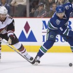 Vancouver Canucks defenseman Yannick Weber (6) fights for control of the puck with Arizona Coyotes center Max Domi (16) during first period NHL action Vancouver,  British Columbia, Monday, Jan. 4, 2016. (Jonathan Hayward/The Canadian Press via AP)
