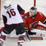 Calgary Flames goalie Karri Ramo, right, from Finland, makes a pad save against Arizona Coyotes' Max Domi during the second period of an NHL hockey game Thursday, Jan. 7, 2015, in Calgary, Alberta. (Larry MacDougal/The Canadian Press via AP)