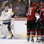 Arizona Coyotes' Tobias Rieder (8) celebrates his first goal during the third period against Nashville Predators' Carter Hutton, left, with teammates Martin Hanzal (11) and Zbynek Michalek (4) in an NHL hockey game Saturday, Jan. 9, 2016, in Glendale, Ariz. Rieder scored two goals in the third period, and the Coyotes defeated the Predators 4-0. (AP Photo/Ross D. Franklin)