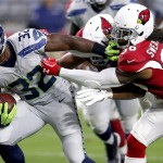 Seattle Seahawks running back Christine Michael (32) tries to break free from Arizona Cardinals defensive back D.J. Swearinger (36) and defensive end Calais Campbell, rear, during the second half of an NFL football game, Sunday, Jan. 3, 2016, in Glendale, Ariz. (AP Photo/Rick Scuteri)