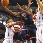Arizona guard Kadeem Allen (5) drives by Southern California forward Nikola Jovanovic, right and Southern California forward Bennie Boatwright, left for the basket during the first half of an NCAA college basketball game, Saturday, Jan. 9, 2016, in Los Angeles. (AP Photo/Gus Ruelas)