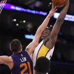 Los Angeles Lakers forward Julius Randle, right, shoots as Phoenix Suns center Alex Len, of Ukraine, defends during the first half of an NBA basketball game, Sunday, Jan. 3, 2016, in Los Angeles. (AP Photo/Mark J. Terrill)