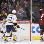 Arizona Coyotes' Tobias Rieder (8) raises his stick after scoring a goal against Nashville Predators' Carter Hutton, left, as Predators' Mike Fisher (12) arrives late to defend during the third period of an NHL hockey game Saturday, Jan. 9, 2016, in Glendale, Ariz.  The Coyotes defeated the Predators 4-0. (AP Photo/Ross D. Franklin)
