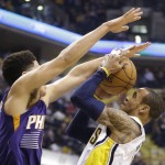 Phoenix Suns guard Devin Booker, left, fouls Indiana Pacers guard Monta Ellis as he shoots during the first half of an NBA basketball game in Indianapolis, Tuesday, Jan. 12, 2016. (AP Photo/Michael Conroy)