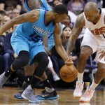 Phoenix Suns' P.J. Tucker (17) and Charlotte Hornets' Kemba Walker (15) battle for a loose ball during the first half of an NBA basketball game Wednesday, Jan. 6, 2016, in Phoenix. (AP Photo/Ross D. Franklin)