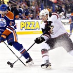 Arizona Coyotes' Connor Murphy (5) battles for the puck with Edmonton Oilers' Benoit Pouliot (67) during second period NHL action in Edmonton, Alberta, on Saturday, Jan. 2, 2016. (Jason Franson/The Canadian Press via AP)