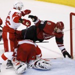Detroit Red Wings' Tomas Jurco (26), of Slovakia, sends Arizona Coyotes' Antoine Vermette (50) over Red Wings goalie Petr Mrazek, bottom, during the first period of an NHL hockey game Thursday, Jan. 14, 2016, in Glendale, Ariz. (AP Photo/Ross D. Franklin)