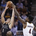 Phoenix Suns' Devin Booker (1) and Cleveland Cavaliers' Iman Shumpert (4) vie for a rebound during the first half of an NBA basketball game Wednesday, Jan. 27, 2016, in Cleveland. (AP Photo/Tony Dejak)