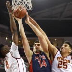 Arizona center Dusan Ristic (14) battles Southern California forward Chimezie Metu (4) and forward Bennie Boatwright (25) for a rebound during the first half of an NCAA college basketball game, Saturday, Jan. 9, 2016, in Los Angeles. (AP Photo/Gus Ruelas)