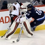Arizona Coyotes' goalie Louis Domingue (35) clears the puck as Winnipeg Jets' Andrew Ladd (16) tries to steal it away during the first period of an NHL hockey game Tuesday, Jan 26, 2016, in Winnipeg, Manitoba. (Trevor Hagan/The Canadian Press via AP)