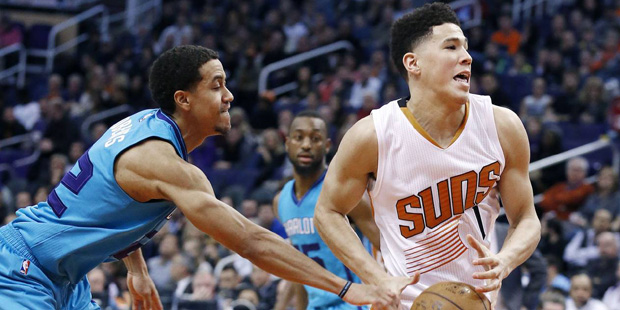 Charlotte Hornets' Brian Roberts, left, strips the ball from Phoenix Suns' Devin Booker (1) during ...