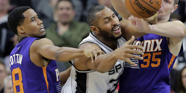 San Antonio Spurs center Boris Diaw, center, loses the ball as he is pressured by Phoenix Suns guar...