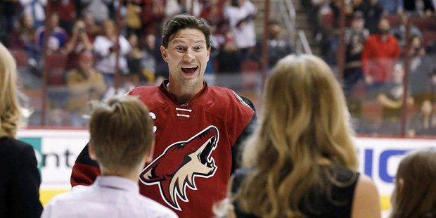 Arizona Coyotes' Shane Doan smiles as he greets his wife and kids as he is recognized for becoming ...