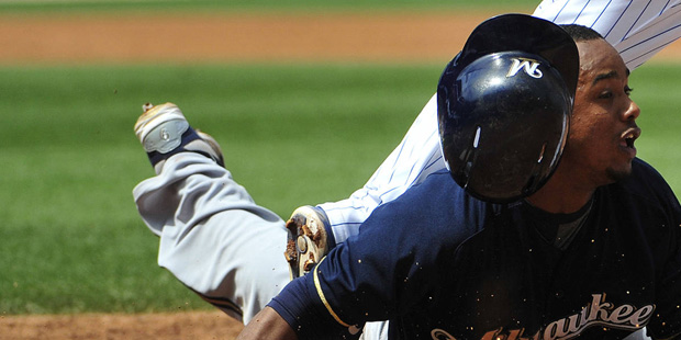 Milwaukee Brewers' Jean Segura (9) dives safely back first base on a pick off attempt by Chicago Cu...